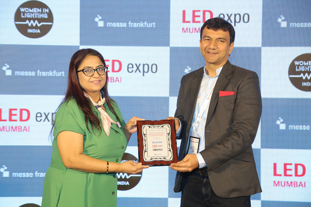 Award ceremony with woman receiving certificate from LLD